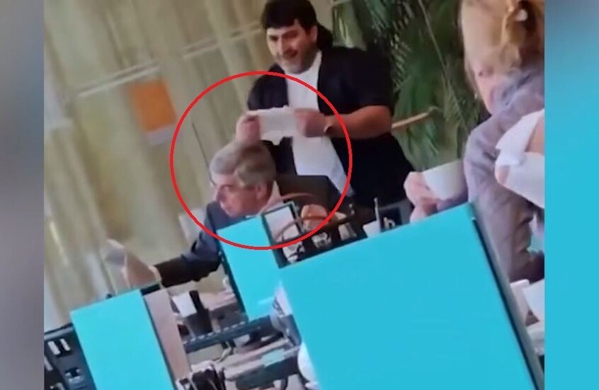 مجهول يضع حفاضة طفل على رأس رئيس اللجنة الأولمبية الدولية في مقهى